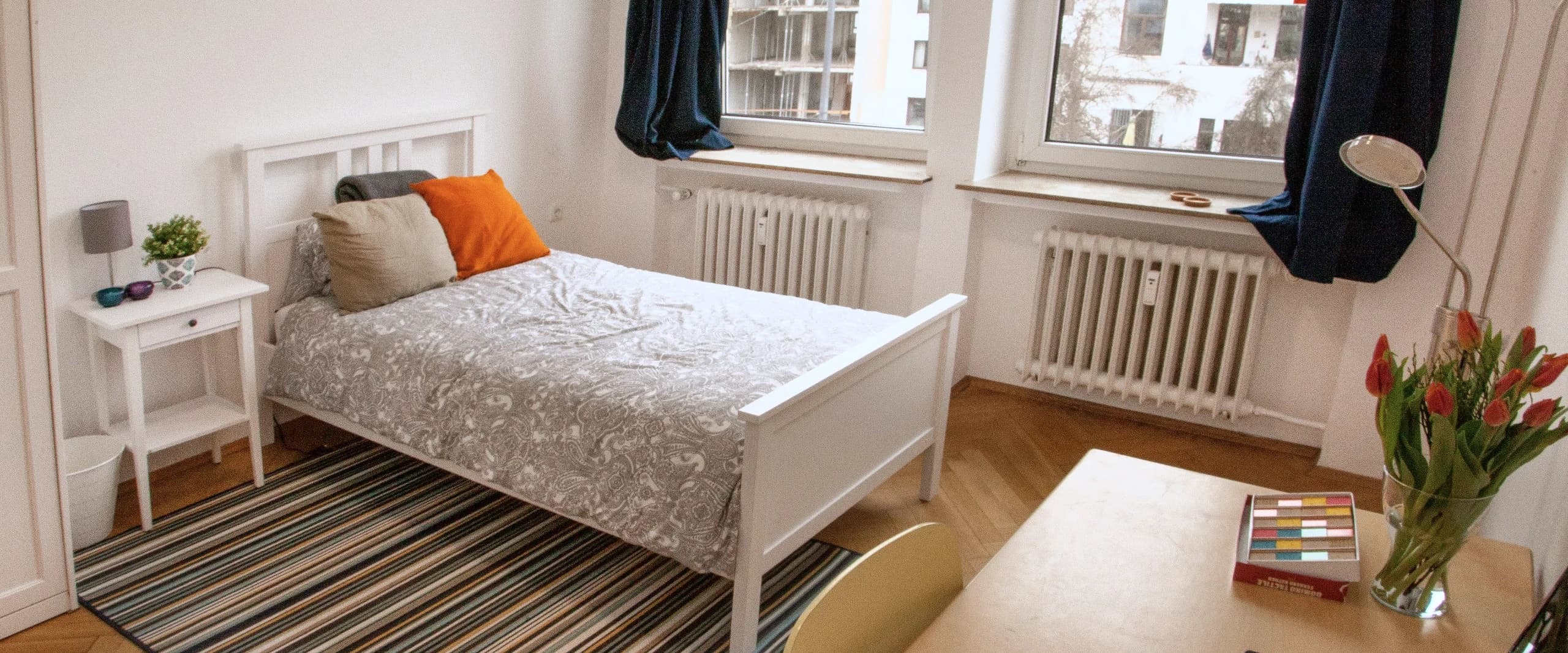 Beispielbild: Ein Einzelzimmer in einer CASA-WG mit Bett und großen Fenstern