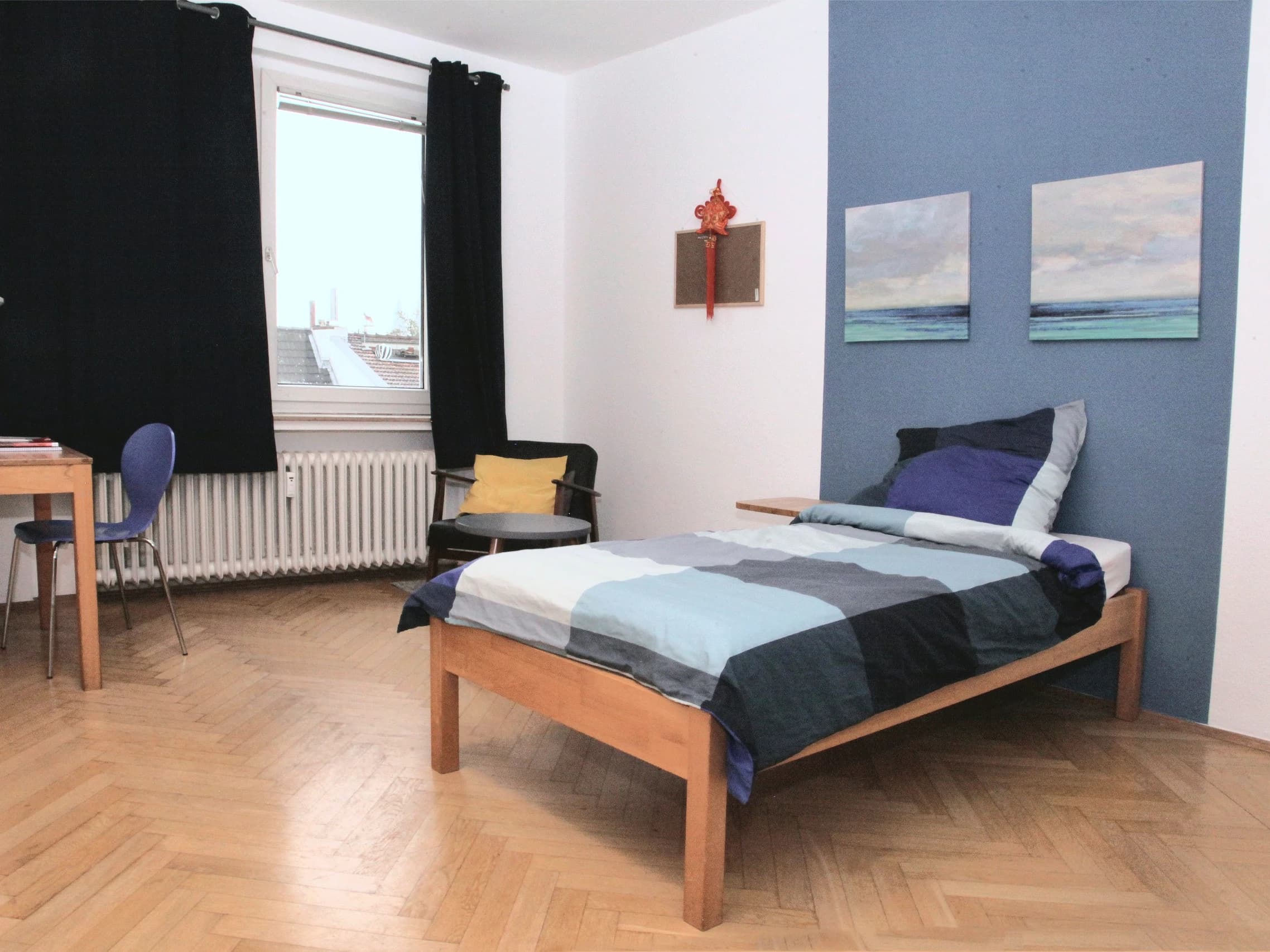 Beispielbild: Ein Einzelzimmer in einer CASA-WG mit Bett, Sessel und Schreibtisch