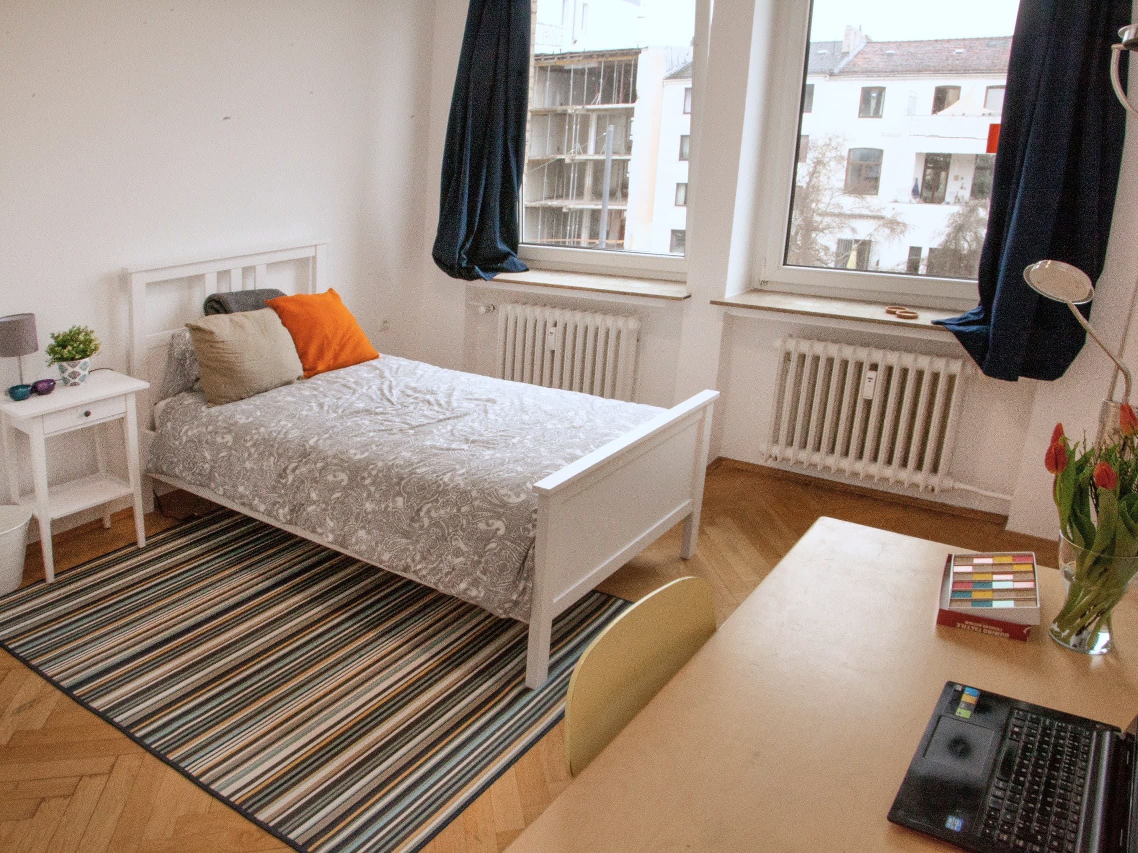 Beispielbild: Ein Einzelzimmer in einer CASA-WG mit Bett, Schreibtisch und Tulpen